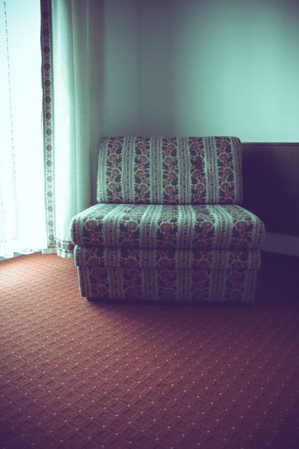 Close-up view of a beige carpet with a decorative brown floral pattern, showcasing a neat and clean surface with a slight sheen that reflects the room's lighting. The carpet's edges are cleanly finished, and a portion of the adjacent beige tiled floor is visible, indicating a well-maintained and hygienic space. The image highlights the effectiveness of professional surface cleaning and carpet maintenance, consistent with services offered by Watford Carpet Cleaning, as discussed in the Vicarage Road carpet and upholstery cleaning success story on their website.
